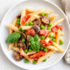 Penne con funghi porcini, piselli, cotto, panna, pomodoro