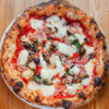 Pizza Capricciosa Pomodoro, fior di latte, cotto, funghi champignon, carciofi, olive, acciughe, origano